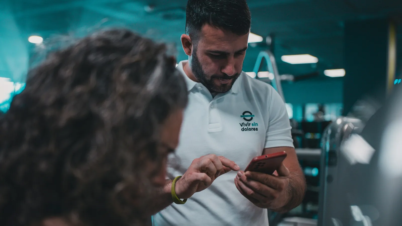 A coach's branded client app on a phone beside a pricing ledger, the cost question this page answers