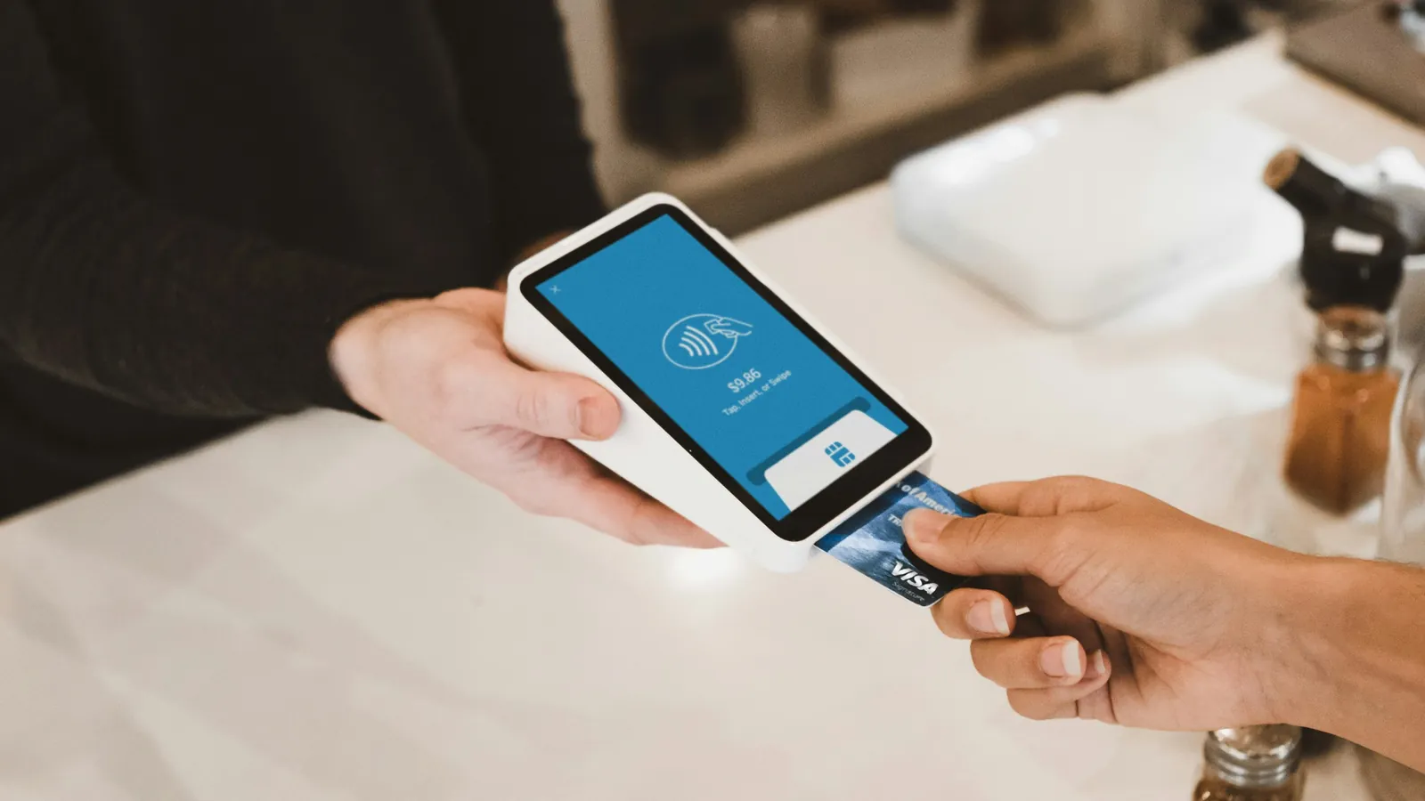 A client tapping a bank card into a handheld card terminal, the payment each Client Billing fee is taken from