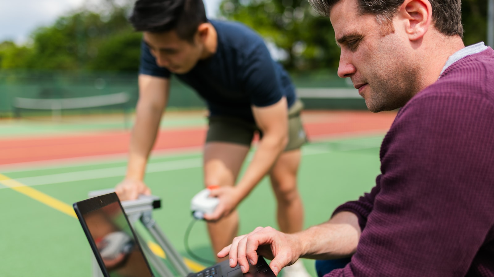 Personal trainer and client reviewing a training plan together, the follow-up conversation a coach has to reopen when a check-in goes unanswered