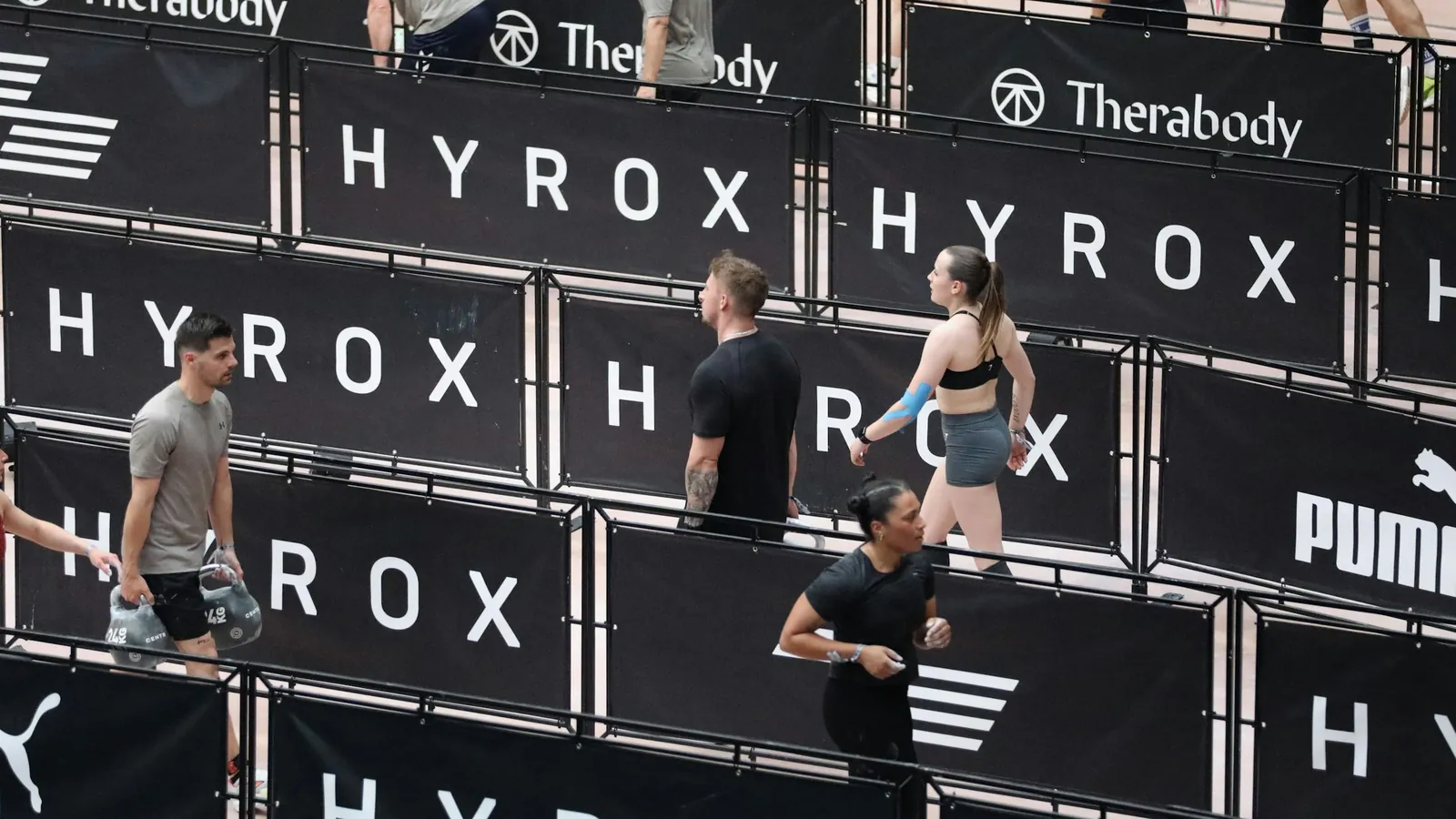 Athletes in club kit at a race venue with a support crew in the same colours, the competition-day presence that makes a HYROX club findable