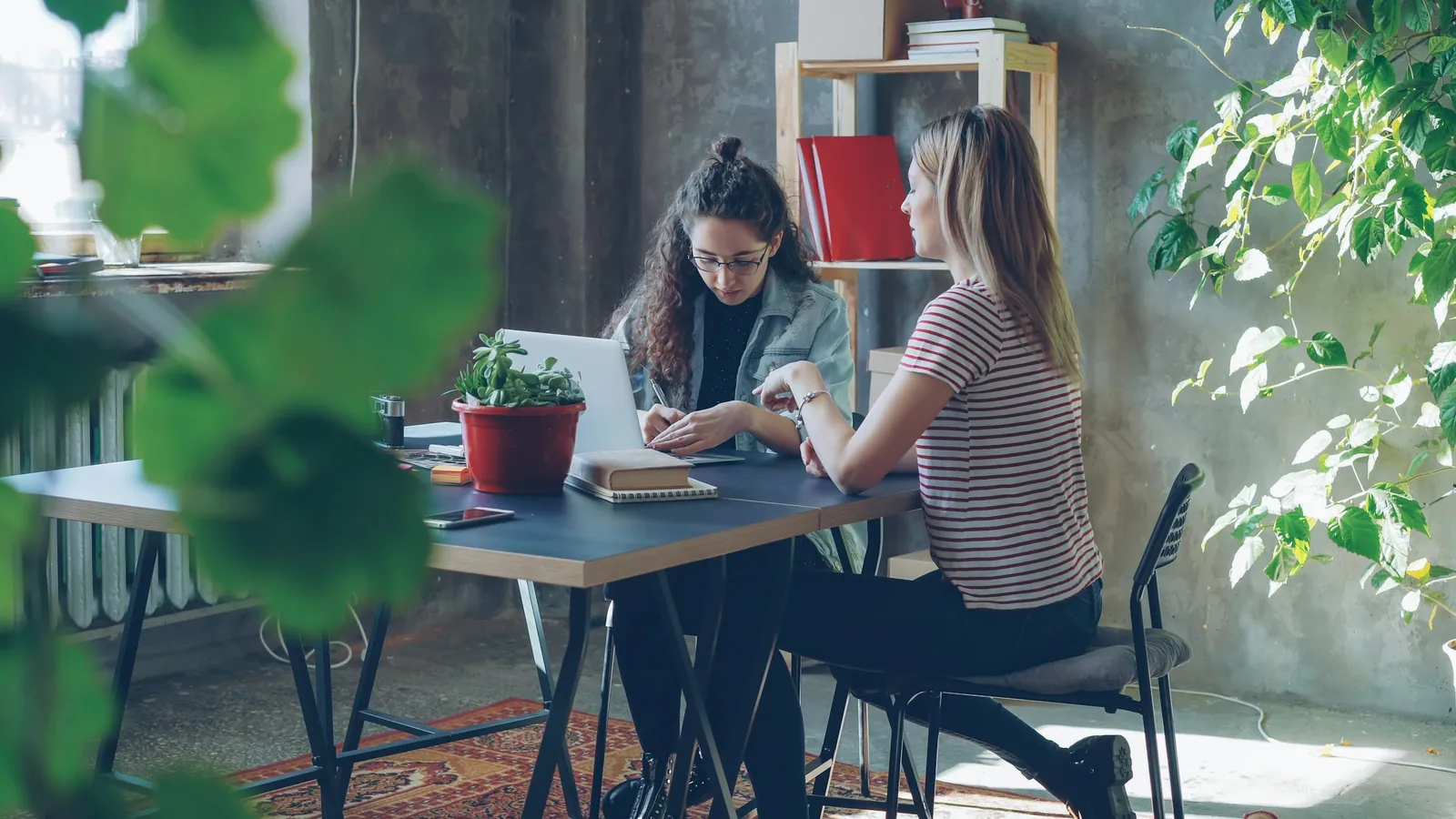 A coach and a client working through a plan together at a desk, the conversation where a scope boundary and a referral get explained