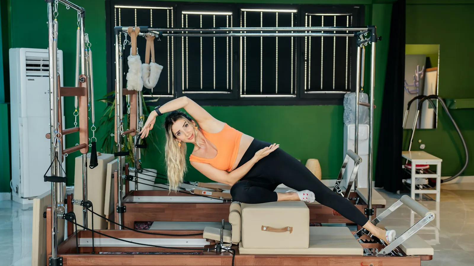 A Pilates instructor's branded client app on a phone, the studio an independent instructor carries in the client's pocket