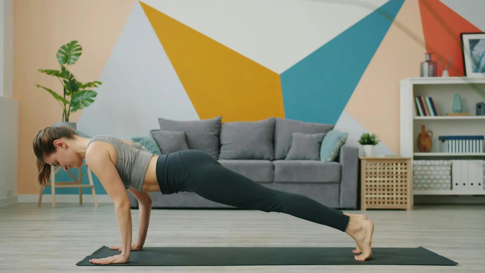 A Pilates instructor building a mat repertoire as a sequenced program on a laptop, mat sessions with video cues in a coaching app